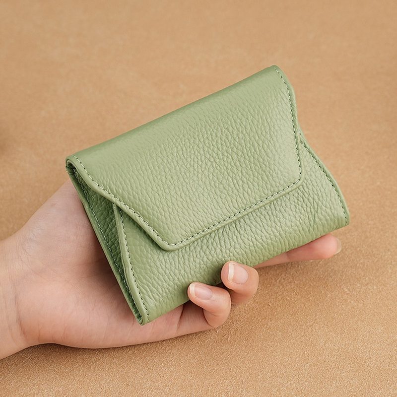 Compact green cowhide leather card holder held in a hand