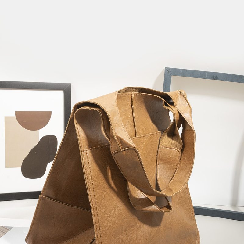 Oversized tan soft tote bag carried over a shoulder