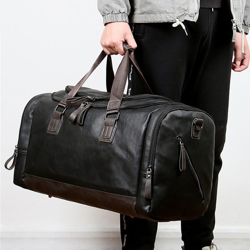 Black structured weekender bag held by a man