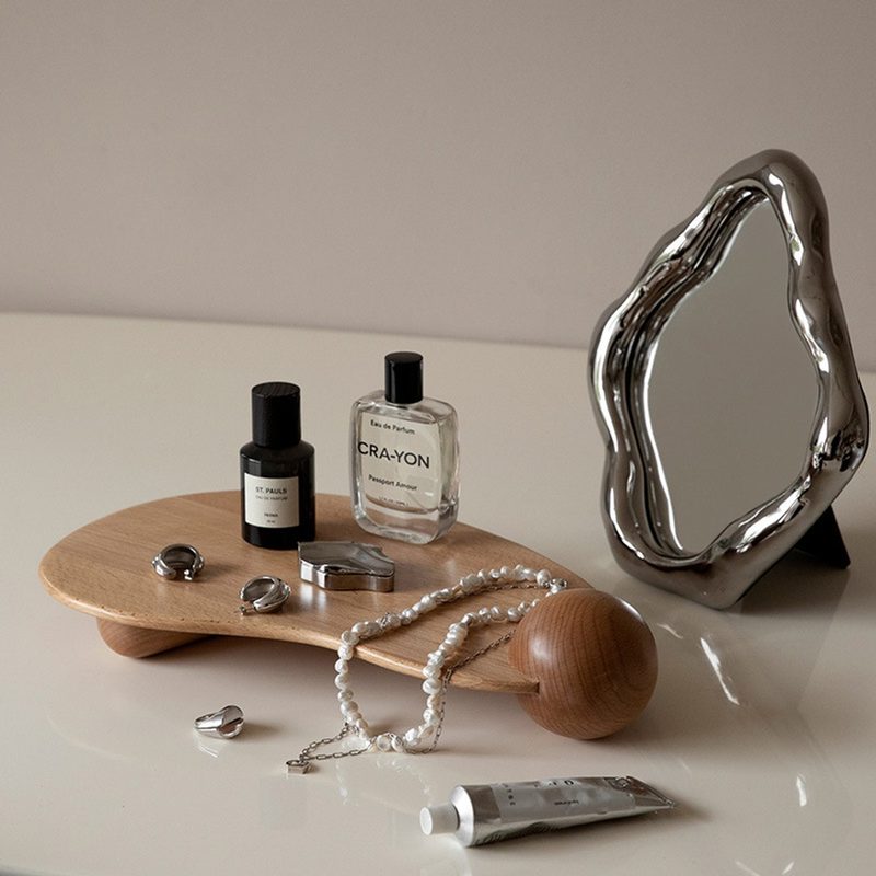 curved wooden display tray with candles and perfume