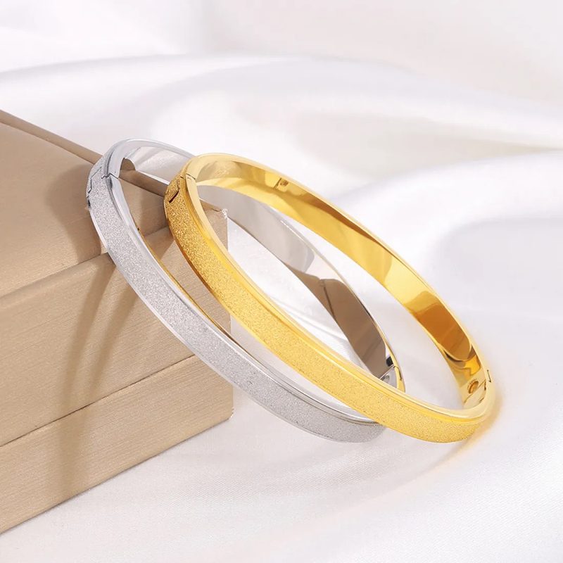 Slim gold tone bangle bracelet with a speckled finish