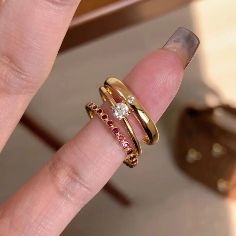 Slim gold tone band ring set with a small coloured stone