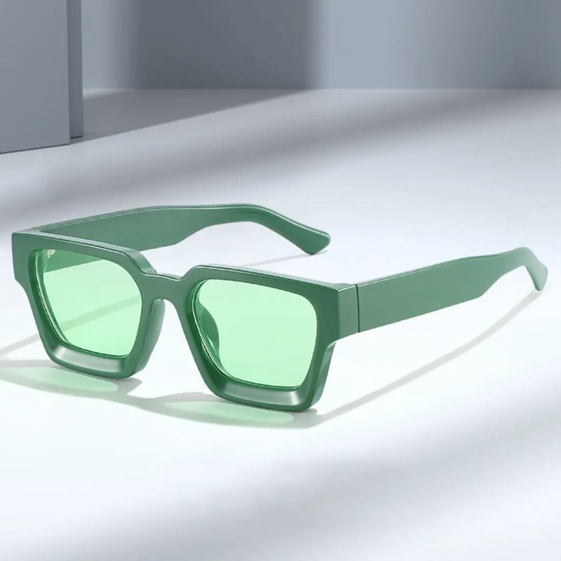 Thick square green fashion sunglasses on a plain background