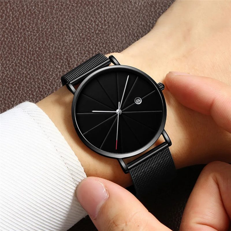 All-black minimalist watch with a mesh strap on the wrist