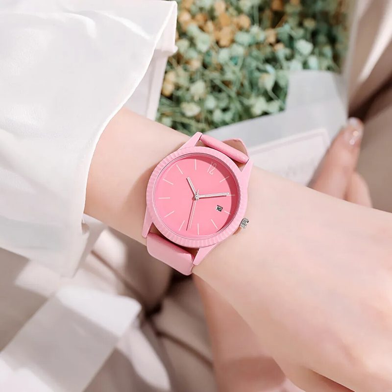 Minimalist pink watch with a plain dial and silicone strap on the wrist